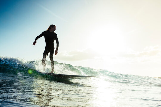 Surfer riding small wave in sea