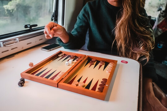Woman playing board game in camper van, Costa Brava, Catalonia, Spain