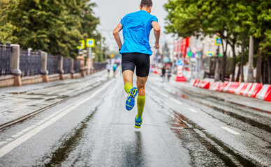 back man athlete running marathon in rainy weather