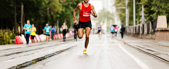leader marathon race athlete runner run in rain on city street