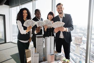 Team of diverse multiethnic business people holding bundle of american dollar cash money, staying...