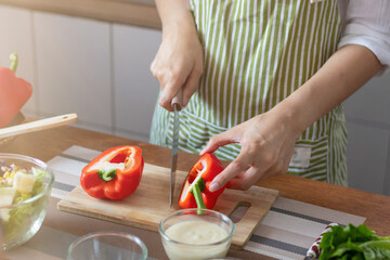 young woman preparing bell Pepper as a breakfast ingredient and ready for healthy cooking and on the table there are vegetables that are healthy organic ingredients. healthy food preparation ideas