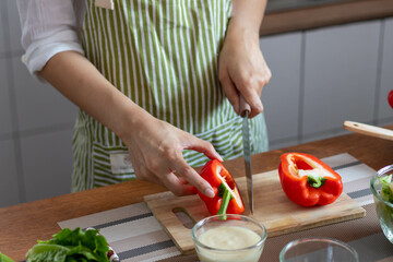 young woman preparing bell Pepper as a breakfast ingredient and ready for healthy cooking and on the table there are vegetables that are healthy organic ingredients. healthy food preparation ideas