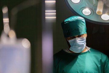 male caucasian doctor working operating room. professional surgical guy wearing mask doing surgery to save patient life in operating room. male nurse wearing mask performing in emergency operation