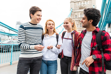 Happy students on Tower Bridge in London during school trip - 573470758