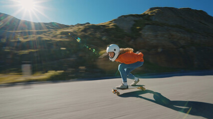 Cinematic downhill longboard session. Young woman skateboarding and making tricks between the...