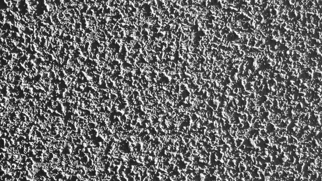 Cement wall with a rough mottled gray surface closeup