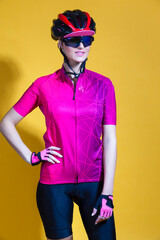 Winsome Positive Female Road Cyclist in Professional Short Sleeve Jersey Outfit Posing Against Yellow Background.