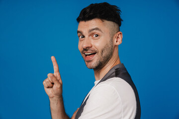 Naklejka premium Young white unshaven man smiling and gesturing finger upwards