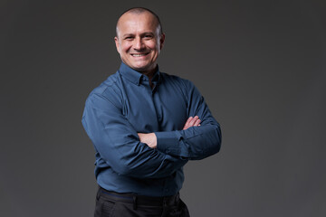 Fototapeta premium Confident smiling businessman on gray background