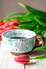 Spring composition with a cup of coffee and tulips.