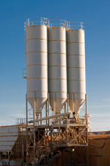 three silos of sand in a gravel pit operation