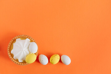 Sweet tartlets decorated with sweets Easter eggs on an orange bright background, close-up. Copy space. Easter delicious dessert.	