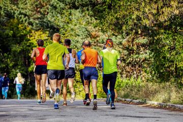 Fototapeta premium group of male runners running marathon race in autumn park