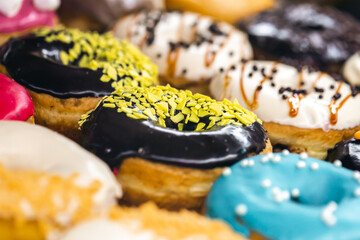 Delicious donuts of different flavors on paper close up.
