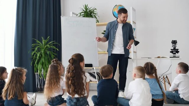 Star letter on the board. Learning new words. Group of children students in class at school with teacher.