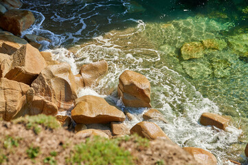 Vom klaren Meer umspülte Felsen im Sonnenschein