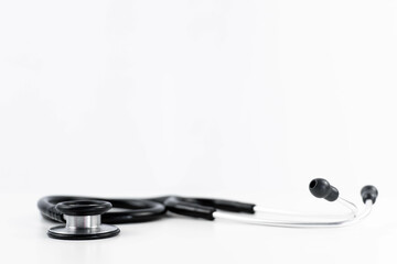 Side view of a medical stethoscope on white background with horizontal copy space perspective banner. Health and medicine concept. Selective focus.
