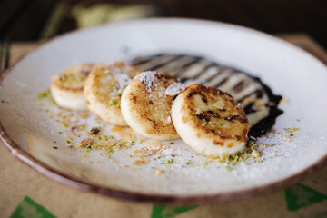 Cheesecakes fried in butter with creamy chocolate cream, grated nuts on top