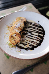 Cheesecakes fried in butter with creamy chocolate cream, grated nuts on top