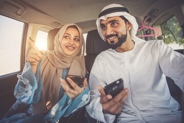 Happy couple driving the car in Dubai. Man and woman going out for shopping. Concept about relationship in the uae