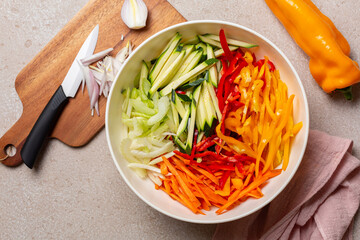 Cutting fresh raw , vegetables, onion, julienne carrot, bell peppers, zucchini, celery.  Knife,...
