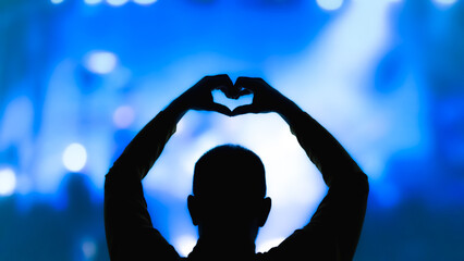 Silhouette of a man with concert stage lights