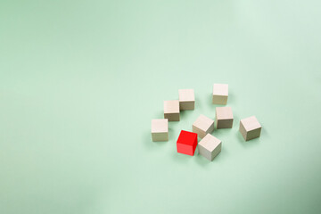Wooden cubes randomly scattered on a green background. Copy space .