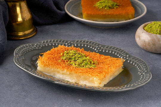 Middle eastern sweets kunefe, kunafa, kadayif with pistachio powder  Turkish , arabic traditional dessert.