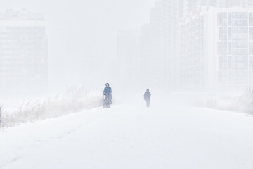 silhouette of a man walking in a snowstorm in the city the concept of a storm blizzard and bad weather.