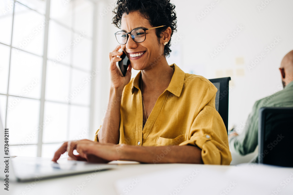 Wall mural Female accountant talking on a phone call in an accounting firm