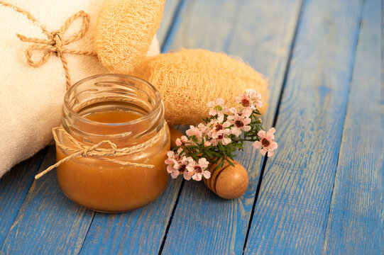 Face mask with manuka honey on blue wooden background.