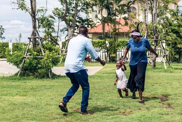 Obraz premium Portrait of enjoy happy love black family african american father and mother with little african girl child smiling and play having fun moments good time in park at home