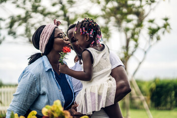 Portrait of enjoy happy love black family african american father and mother with little african girl child smiling and play having fun moments good time in park at home