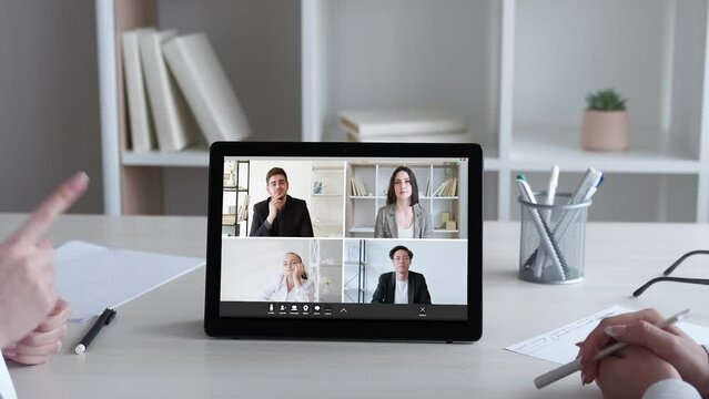 Web conference. Video meeting. Corporate webinar. Diverse business team discussing work project online on tablet at virtual office.