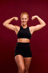 Fototapeta na wymiar Portrait of a smiling female fitness trainer with a muscular body and spotted skin.