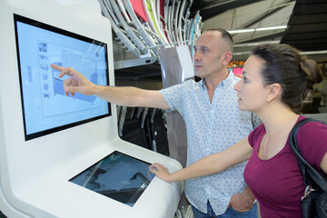 Fototapeta na wymiar couple using a information screen in a store