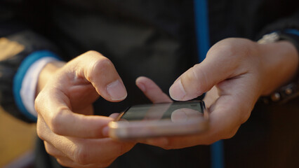 the man using a smartphone for playing games or chatting and social media while outdoor camping