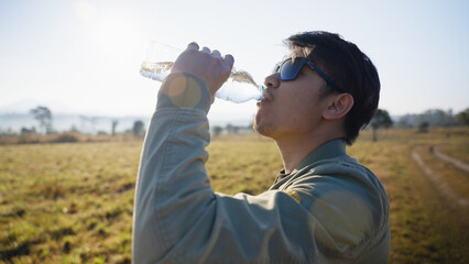 the man drinking water while outdoor travel in the morning