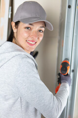 female carpenter at work using hand drilling machine