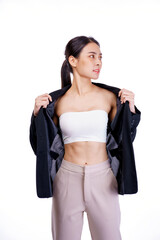 Smiling asiean woman showing abdominal muscles and wearing suit poses in white background.