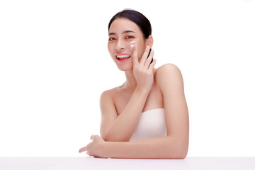 Close up beauty portrait of a smilling beautiful woman wairing white shirt covers only the chest.applying face cream and look at camera. isolated over white background.
