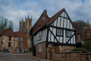 Old english house with view of lincoln cathedral church behind 