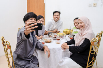 Young muslim people taking selfie during eid mubarak or break fasting moment.