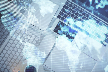Business theme hologram drawings over computer on the desktop background. Top view. Multi exposure. Concept of international connections.