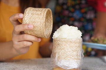 Female hand opening a box of glutinous rice