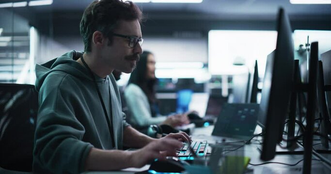 Portrait of a Thoughtful Engineer Working on Desktop Computer in a Technological Office Environment. Research and Development Department Writing Software Code for an Advanced Neural Network Project
