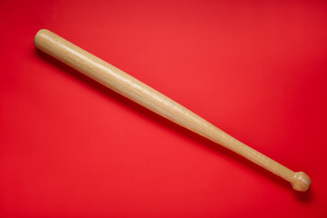 Wooden baseball bat on red background, top view. Sports equipment