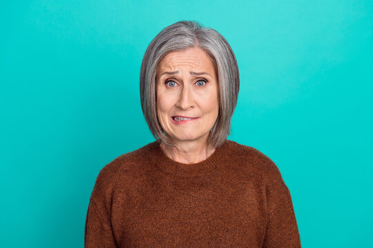 Portrait of unsatisfied nervous person biting lips worrying isolated on turquoise color background