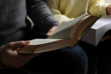Couple sitting and reading holy Bibles, closeup
